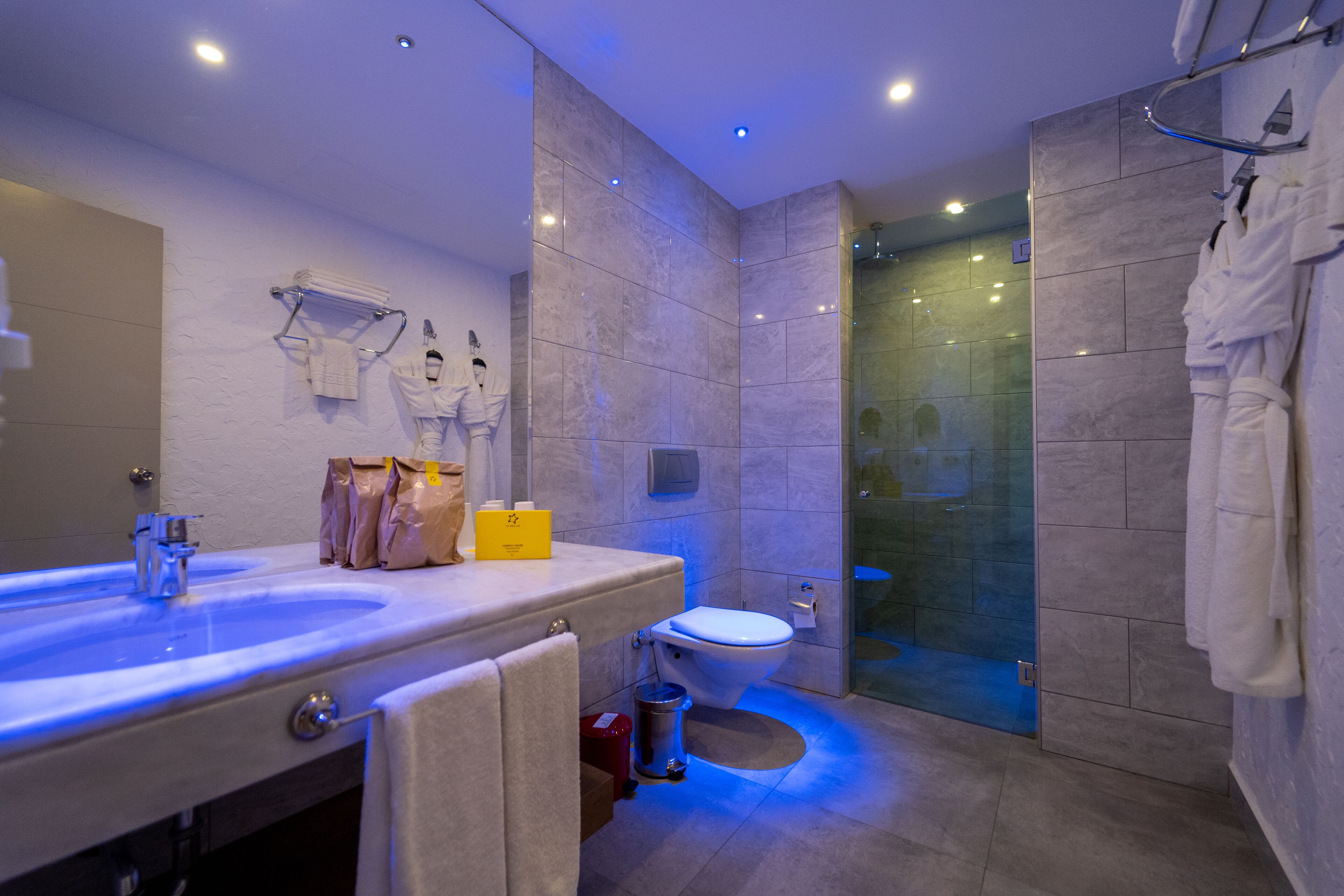 Un baño moderno con un lavabo grande, inodoro y ducha con cerramiento de vidrio.