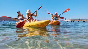 Three people kayaking on a clear day.