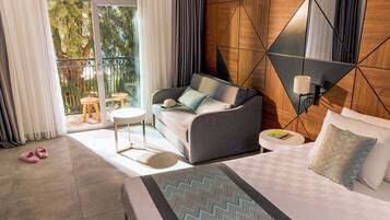 Une chambre d’hôtel avec un lit, un canapé, une petite table et une vue sur l’extérieur.