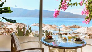 A table with food and drinks, overlooking a beach with umbrellas and cacti. - TUI MAGIC LIFE Bodrum - Adults Only (16+) - All Inclusive (Bodrum)