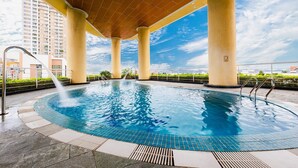 A rooftop swimming pool with a clear view of the city skyline, surrounded by large columns and a covered area. - Muong Thanh Grand Ha Long Hotel (Bai Chay)