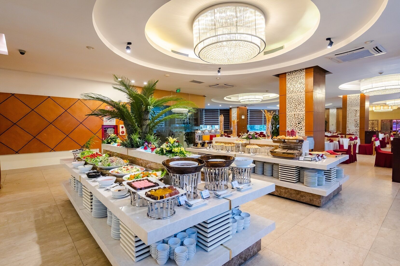 A buffet setup with various food items and a modern interior design.
