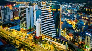 A cityscape with modern high-rise buildings, including a hotel with a prominent sign. - Muong Thanh Grand Ha Long Hotel (Bai Chay)