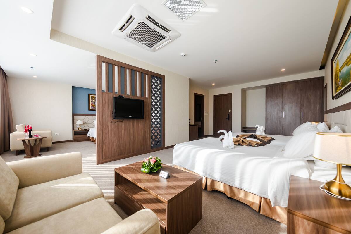 A hotel room with a large bed, a TV, a desk, and a chair.