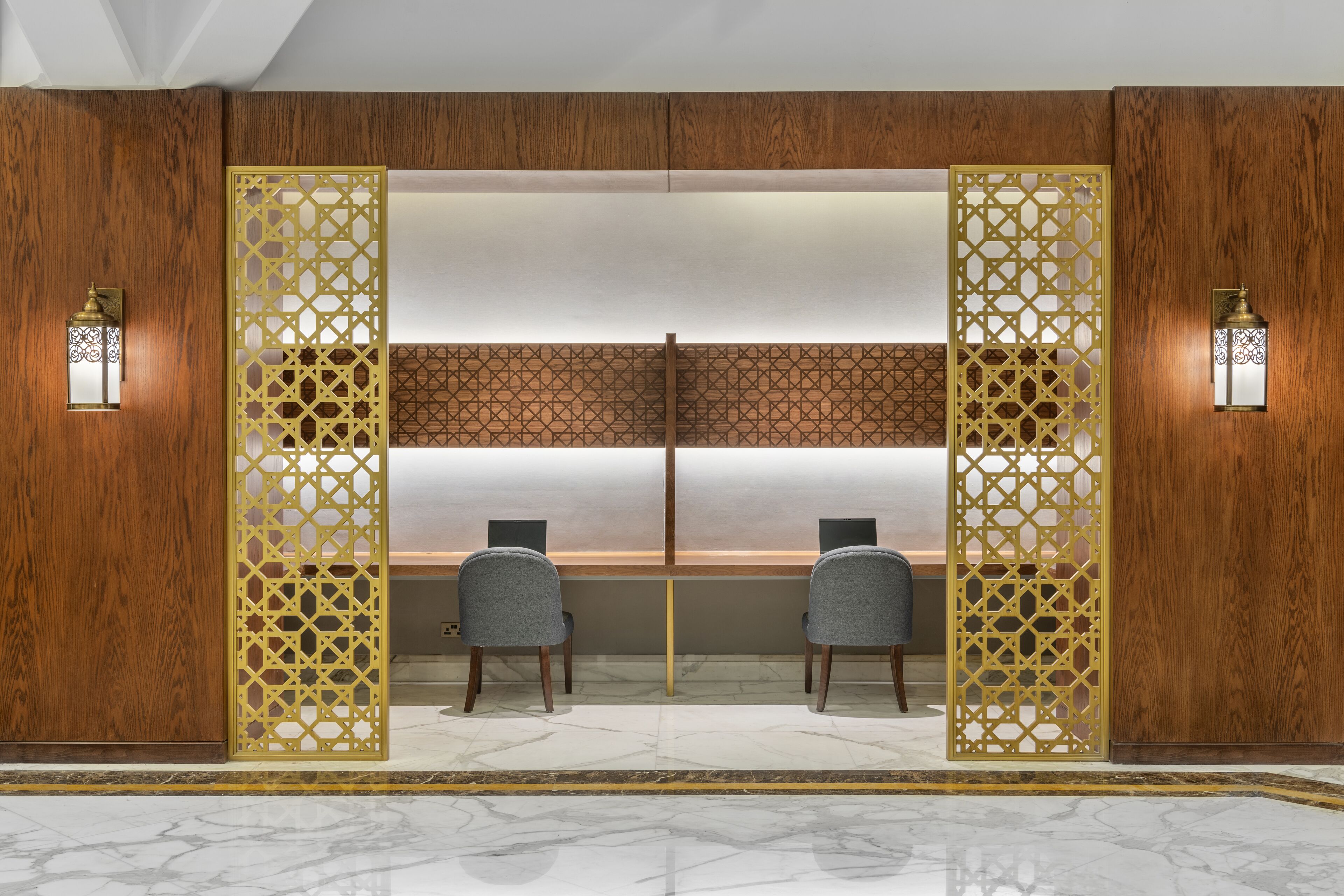 A room with two chairs facing a large window, wooden paneling, and decorative screens.