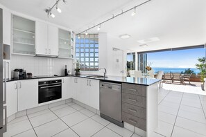 Penthouse | Privékeuken | Een koelkast met diepvriezer, een microgolfoven, een oven, een kookplaat