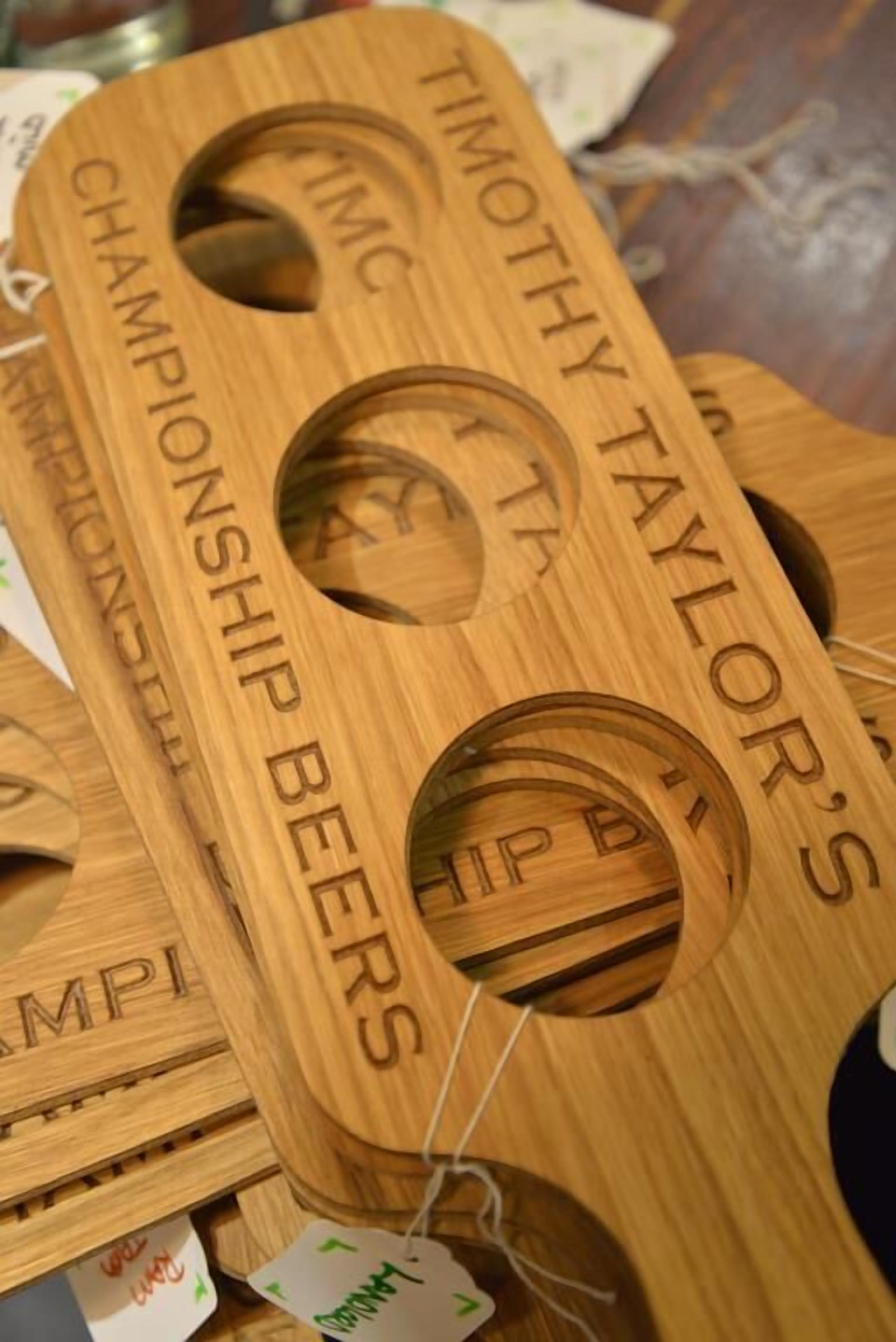 Wooden beer pong boards with names engraved on them.