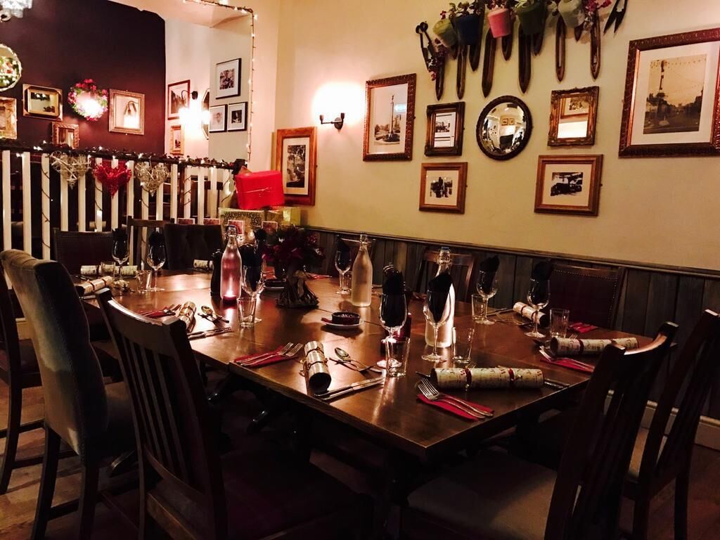 Un comedor con una larga mesa dispuesta para una comida, rodeada de sillas.