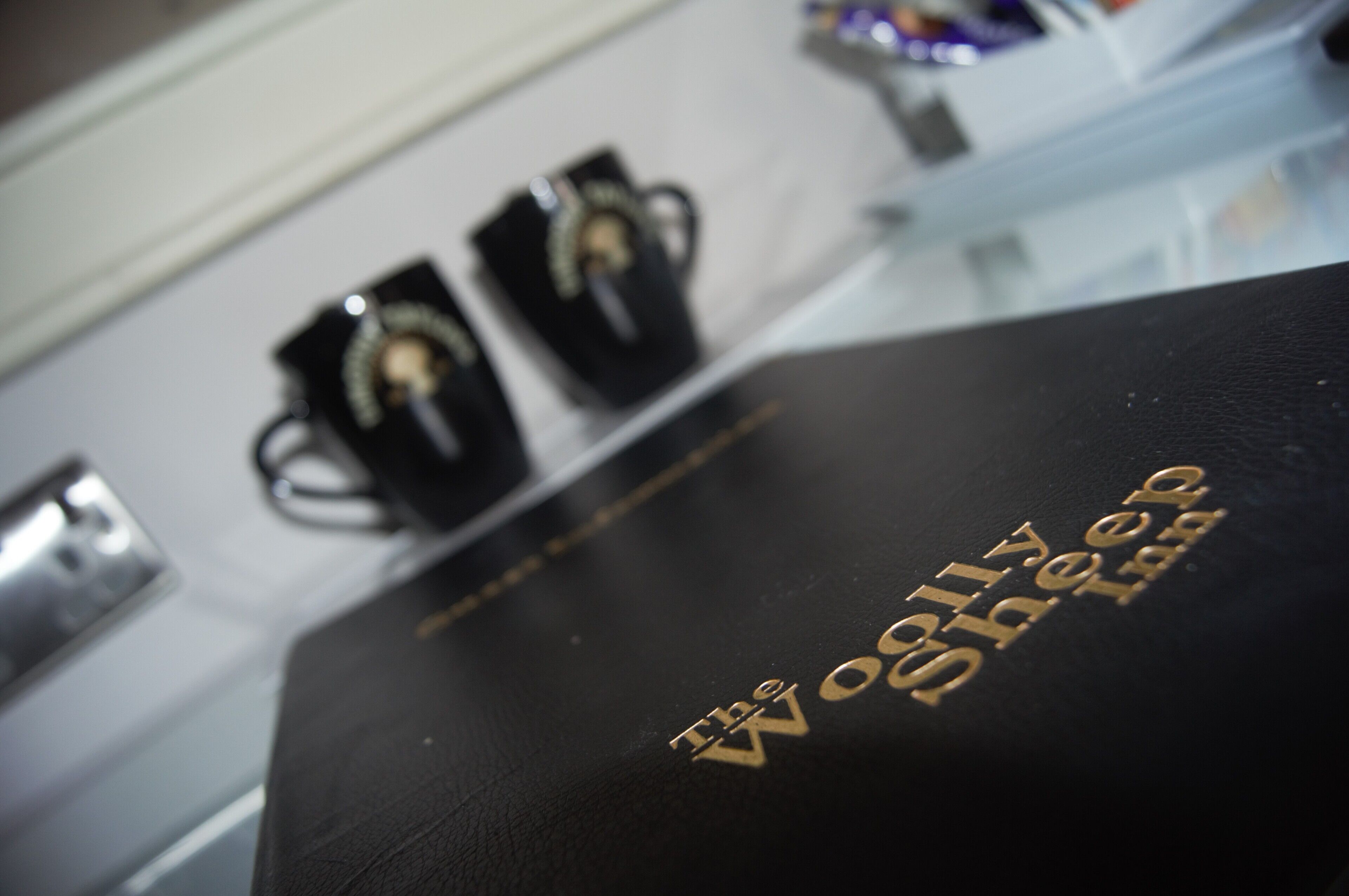 A black leather wallet with the text "The Woolly Sheep" embossed on it.