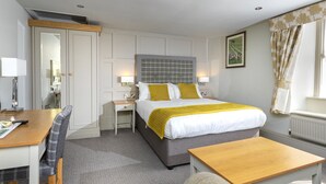 A hotel room with a bed, a desk, a chair, a small table, and a sofa. - The Woolly Sheep Inn (Skipton)
