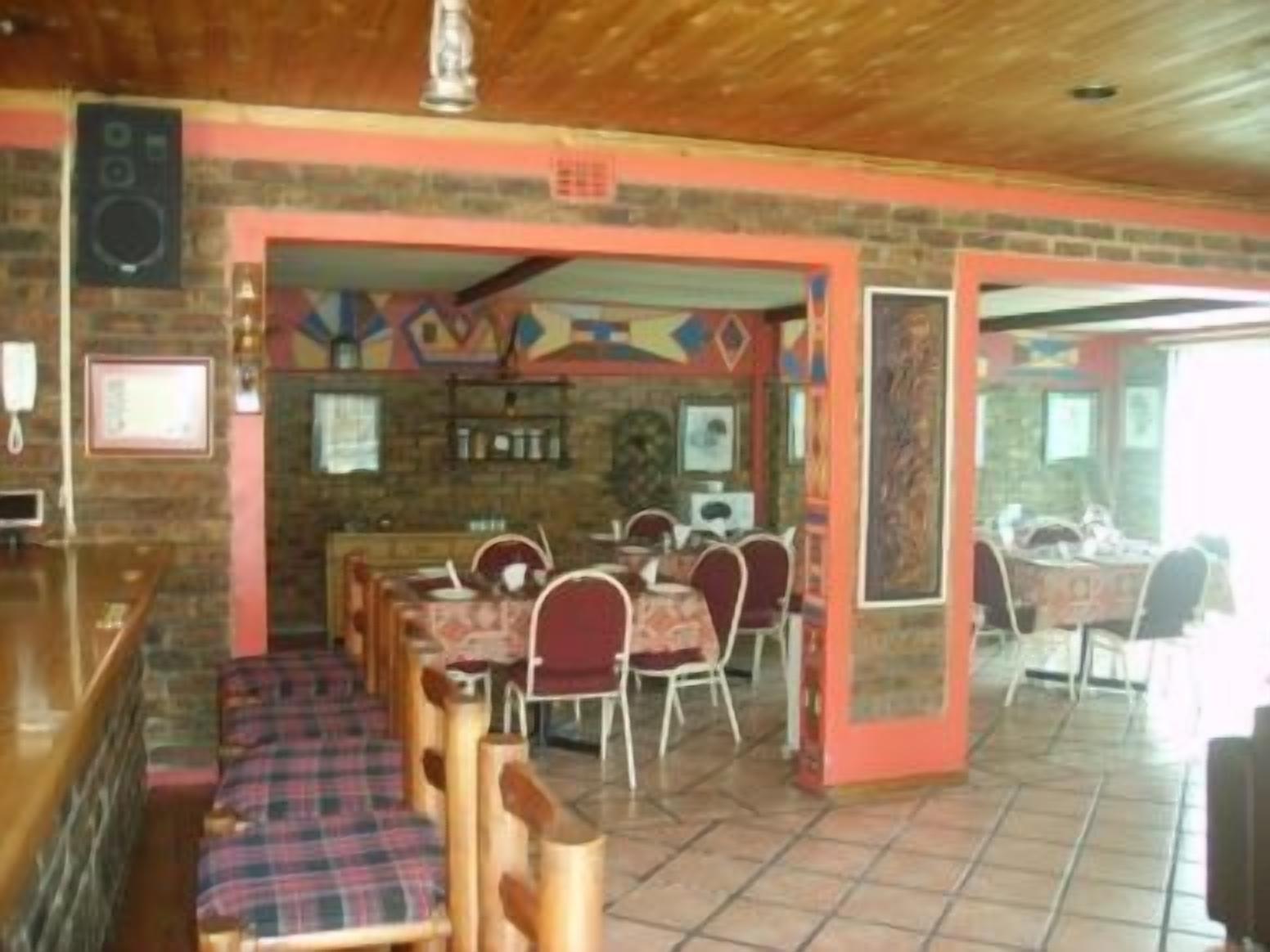 Un restaurante con zona de bar, varias mesas y sillas.