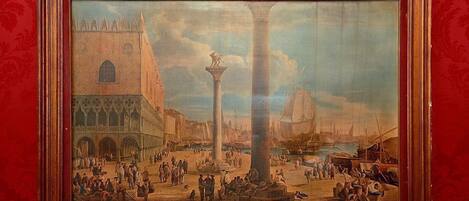 A framed painting of a bustling square with a prominent column, a church, and a ship in the background.