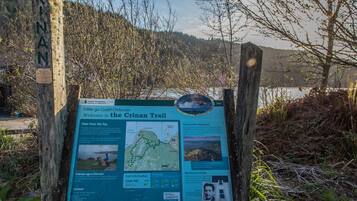 A trail sign with information about the Crinan Trail, including a map and photos of the area.