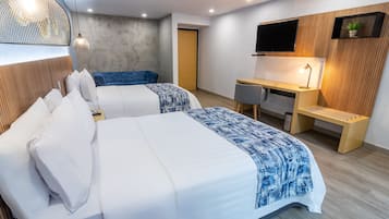 A modern hotel room with two beds, a desk, a TV, and a small plant.