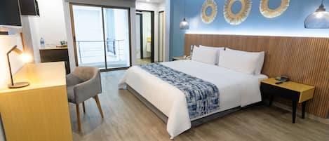 Hotellihuone, jossa on sänky, työpöytä, tuoli ja näkymä ulos.