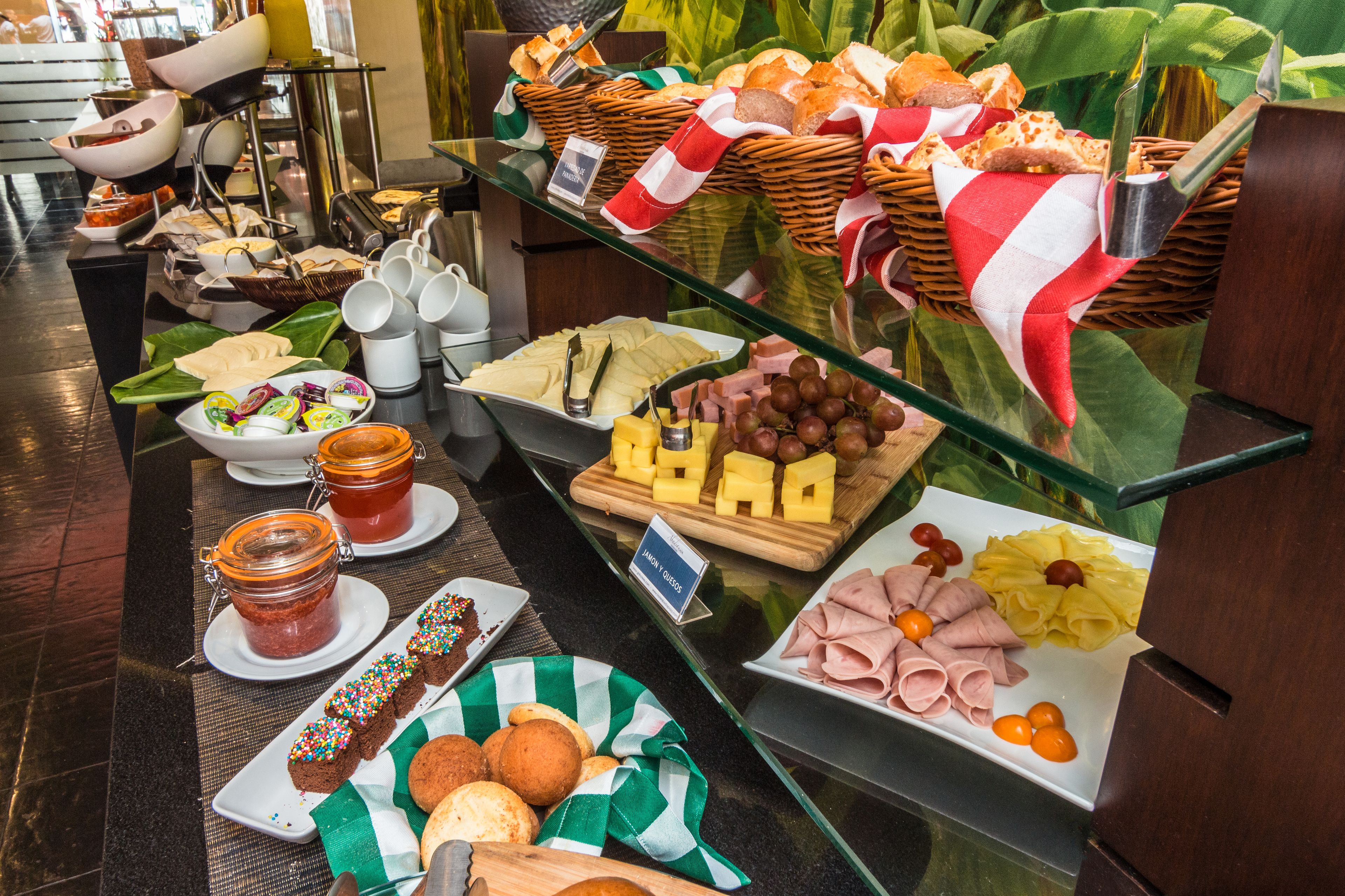 Un bufé con diferentes opciones de comida, como pan, queso y embutidos.
