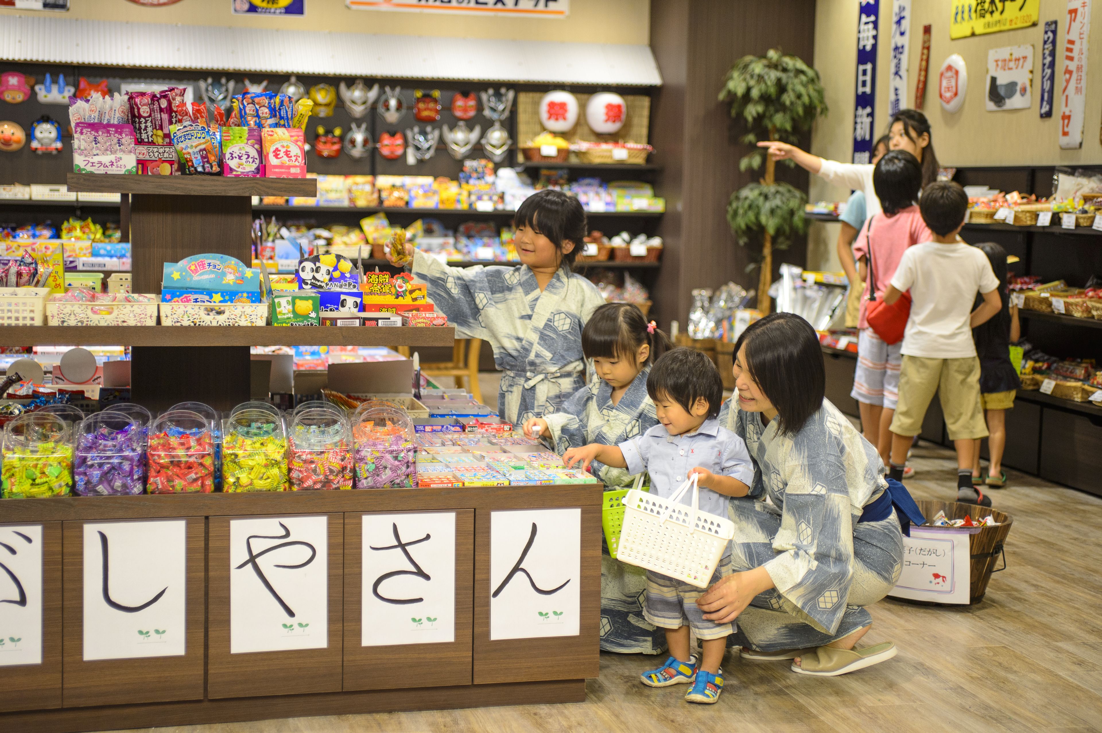 A store with shelves stocked with various items and a display of colorful candies.