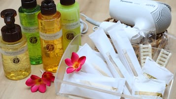 A variety of toiletries including hair and body shampoo, a hairdryer, and shower accessories.
