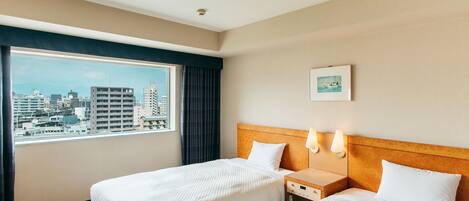 A hotel room with two beds, a large window with a city view, a headboard, bedside lamps, and a small bedside table.