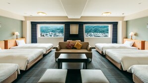 Una habitación de hotel con dos camas, un sofá, una mesa y un televisor.