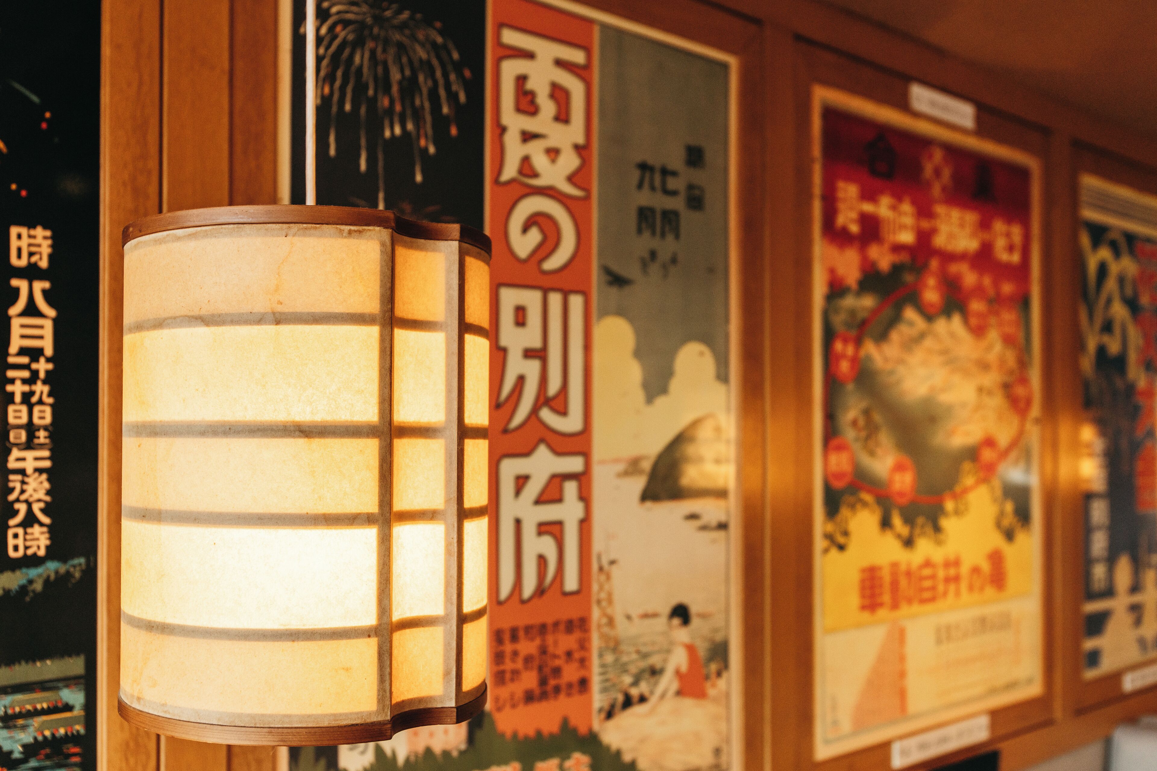 Un mur orné d’affiches et une lanterne japonaise traditionnelle.