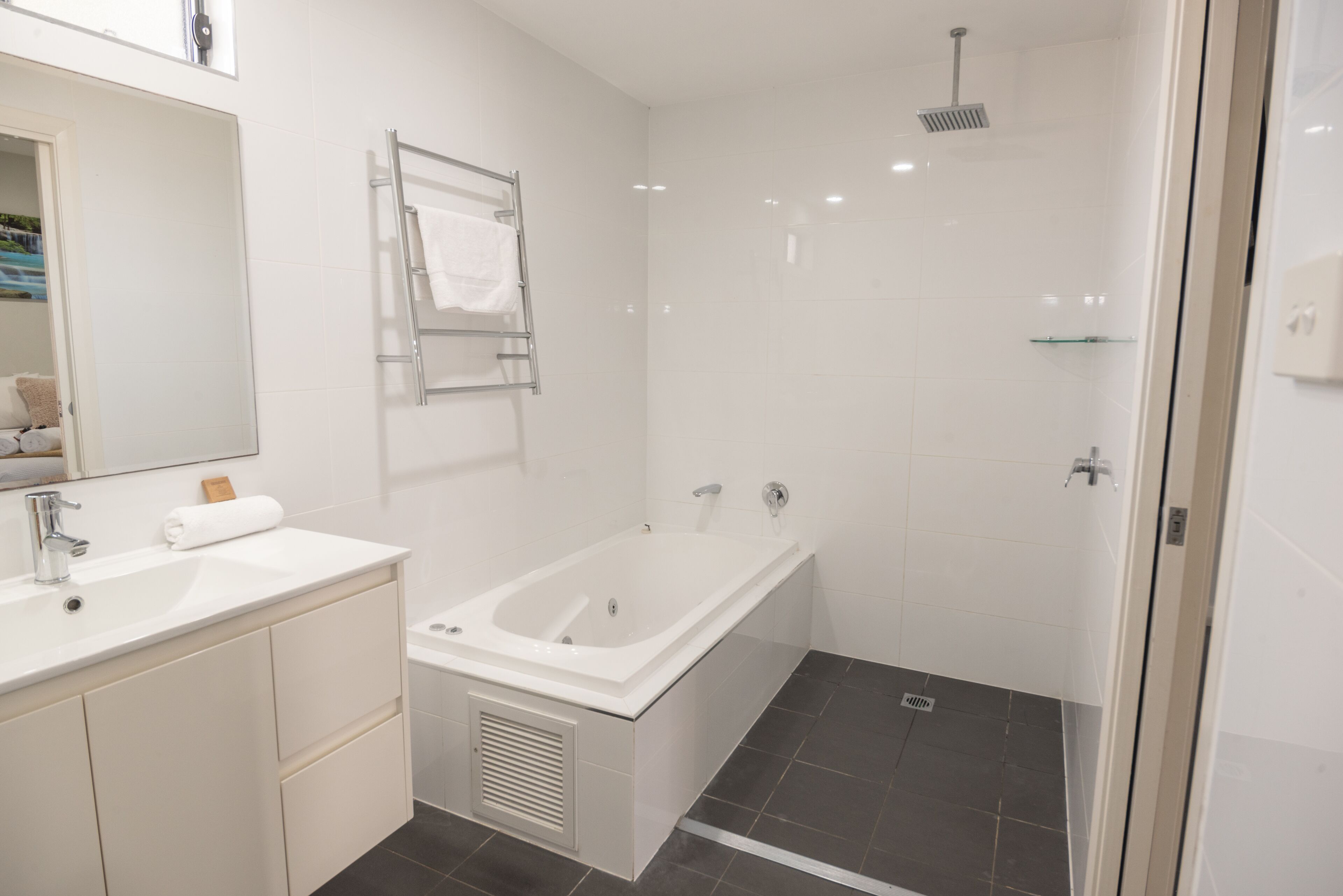 Une salle de bain moderne avec un lavabo blanc, une baignoire et une douche.