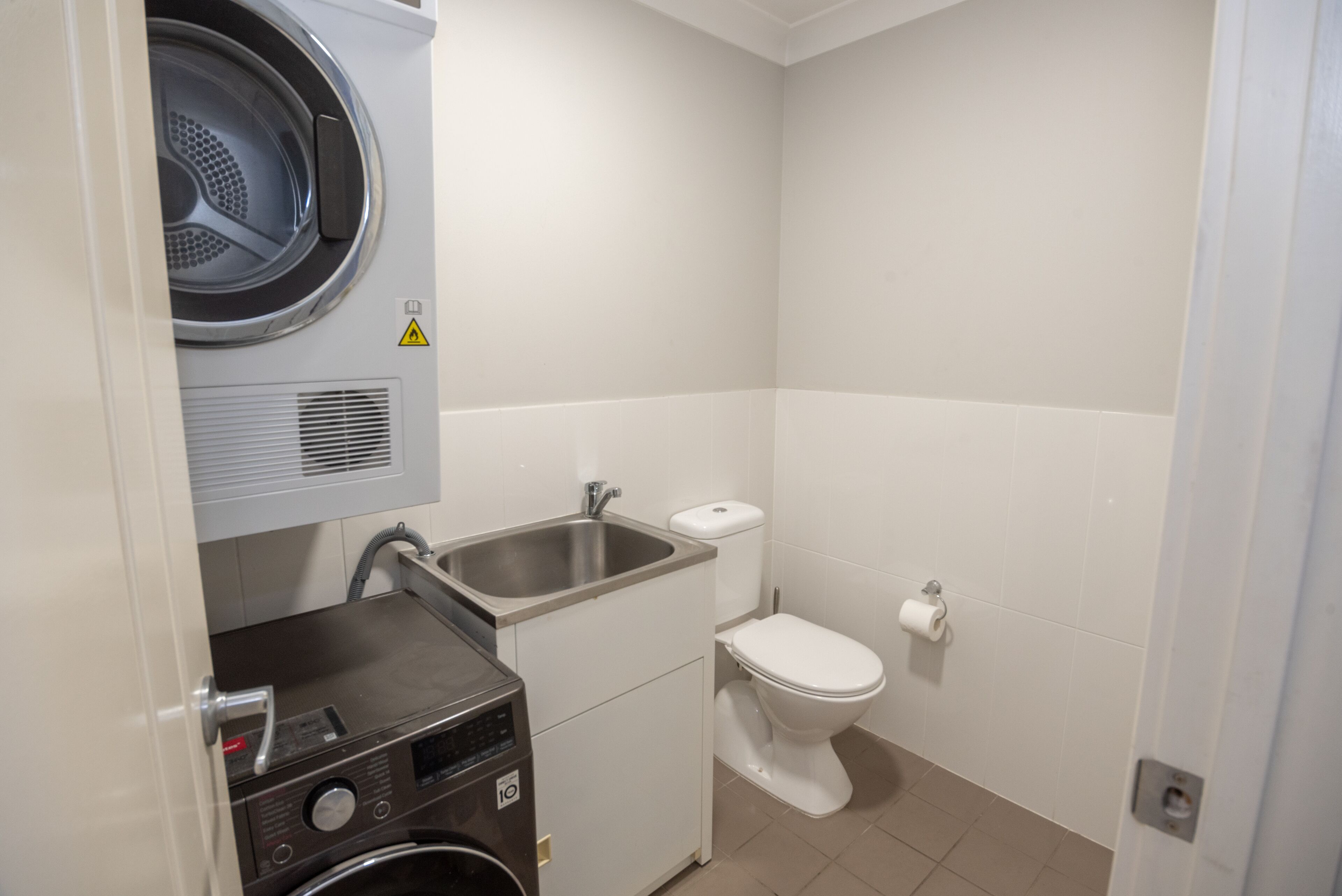 Un bagno piccolo ma funzionale, con lavatrice, lavandino e water.