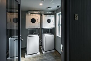 A laundry room with two wall-mounted washing machines and a built-in dryer. - Hotel Mystays Nagoya Nishiki (Nagoya)