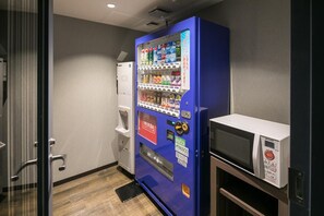 A vending machine with a microwave and a refrigerator in a room. - Hotel Mystays Nagoya Nishiki (Nagoya)