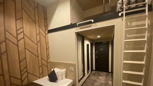 A hotel room with a bed, a small desk, a wardrobe, and a walk-in closet. - HOTEL LiVEMAX Esaka (Suita)