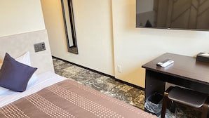 A hotel room with a bed, a desk, a chair, a TV, and a trash bin. - HOTEL LiVEMAX Shin-Osaka (Osaka)