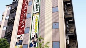 A building with a sign reading "LIVE MAX" and multiple banners advertising hotel services. - HOTEL LiVEMAX Shin-Osaka (Osaka)