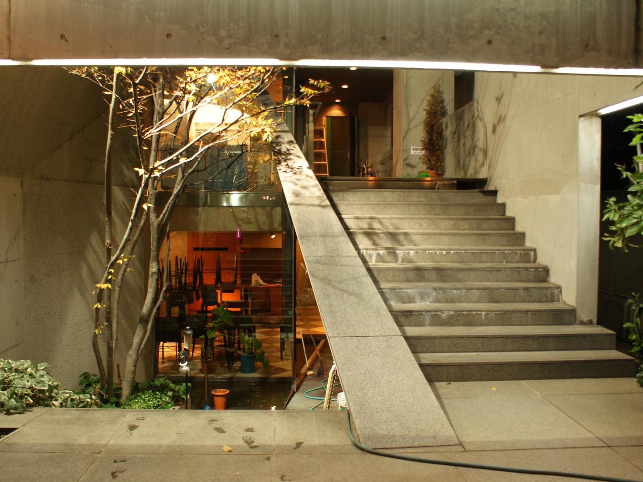 A staircase with a glass balustrade leading to a room with a visible interior.
