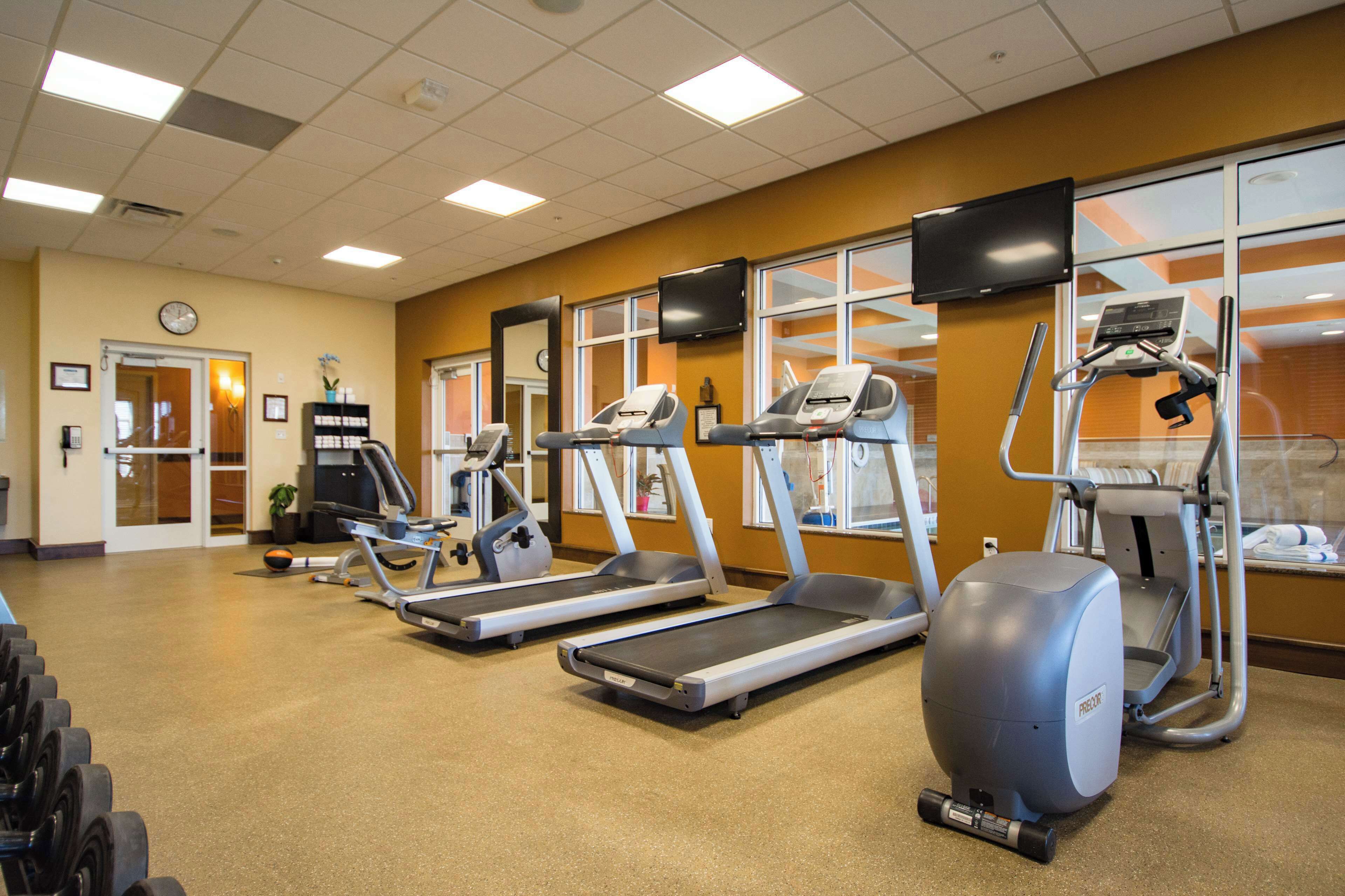 A gym with treadmills, elliptical machines, and a stationary bike.