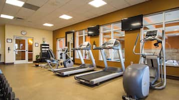 A gym with treadmills, elliptical machines, and a stationary bike.