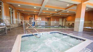 A hotel pool area with multiple hot tubs, a reception desk, and seating areas. - Hilton Garden Inn Watertown/Thousand Islands (Watertown)