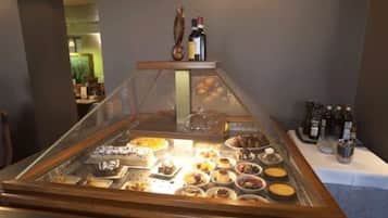 A buffet area with various dishes and a selection of wine bottles.