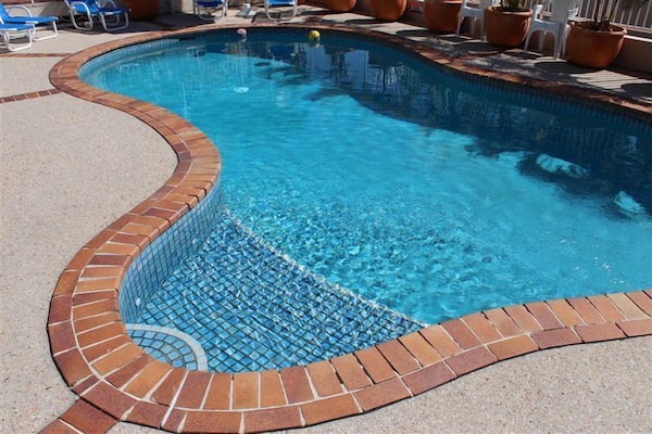 Outdoor pool, a heated pool, pool umbrellas, pool loungers