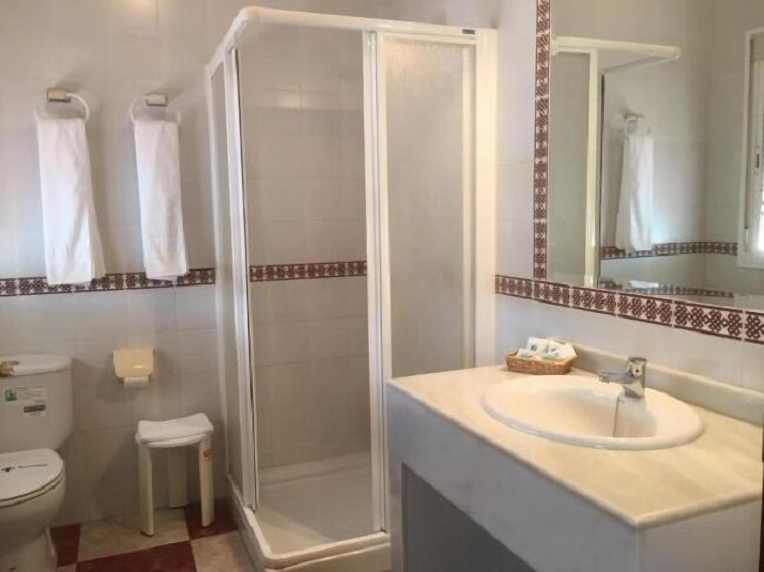 A bathroom with a shower, toilet, and sink.