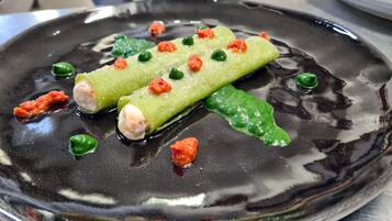 Un plato con sushi enrollado y hojas verdes.
