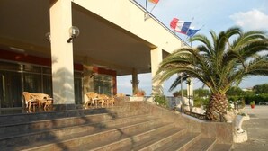 A building with a set of outdoor stairs leading to a covered entrance area. - Le Dune (Castel Volturno)