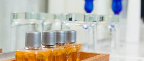 A wooden tray with several amber-colored bottles, likely containing essential oils, on a marble countertop.