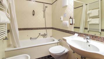 A bathroom with a bathtub, toilet, sink, and a mirror.