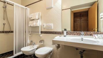 Un bagno con doccia, WC e lavandino.