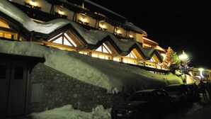 Un edificio cubierto de nieve con numerosas ventanas y un muro de piedra.