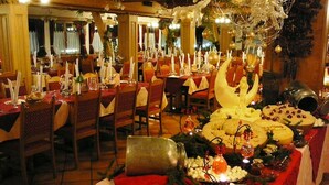 Un restaurante con varias mesas dispuestas para comer, que presenta una variedad de comidas y decoraciones.