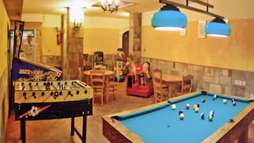 Enjoy social gatherings and games in this room with a pool table, foosball table, and comfortable seating.
