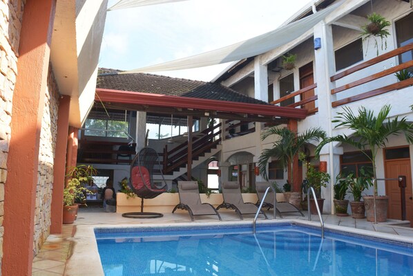 Alberca al aire libre y camastros 