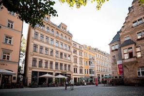 A historic building with multiple stories, large windows, and a cobblestone street. - TOWNHOUSE Leipzig (Leipzig)