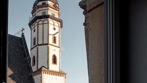 Blick auf ein historisches Gebäude mit einem markanten Turm und einem Balkongeländer.